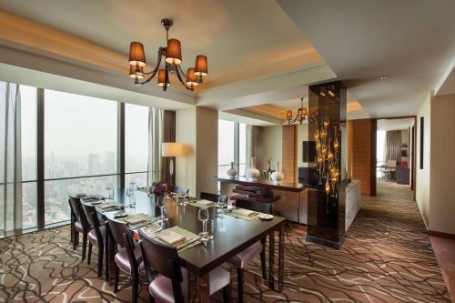 a dining room with a long table and some windows at Hilton Shijiazhuang in Shijiazhuang