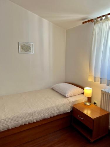 a bedroom with a bed and a table with a lamp at Villa Adria in Vodice