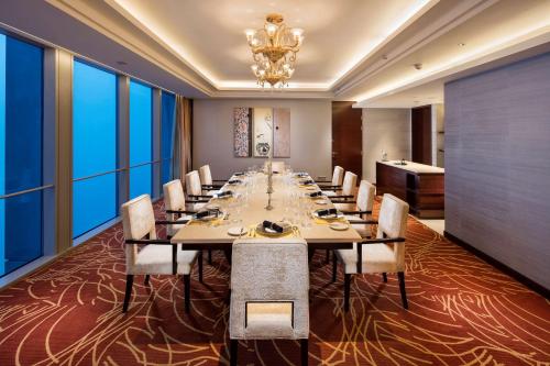 a conference room with a long table and chairs at Hilton Shijiazhuang in Shijiazhuang