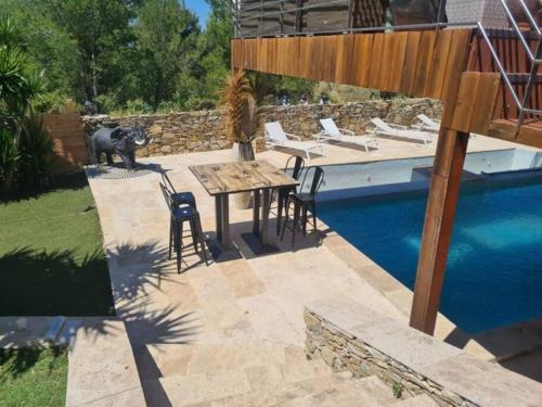 un patio avec une table et des chaises à côté d'une piscine dans l'établissement Villa Allegra T2 60M2, au Beausset