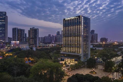 ein hohes Gebäude mit Licht in einer Stadt in der Unterkunft DoubleTree By Hilton Shenzhen Nanshan Hotel & Residences in Shenzhen