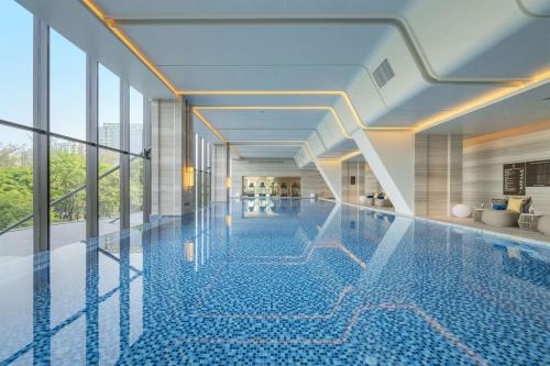 una piscina en un edificio con ventanas de cristal en DoubleTree By Hilton Shenzhen Nanshan Hotel & Residences en Shenzhen