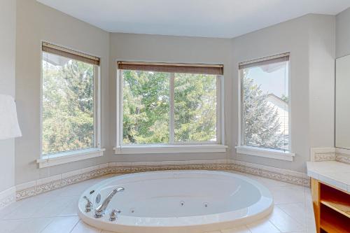 a large white bathroom with a tub and two windows at Soft Tail Sanctuary in Bend