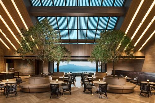 a restaurant with tables and chairs and a large glass ceiling at Conrad Hangzhou Tonglu in Yinzhu