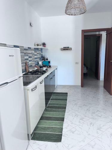a white kitchen with a stove and a refrigerator at Appartamento il sole 2 piano in Realmonte