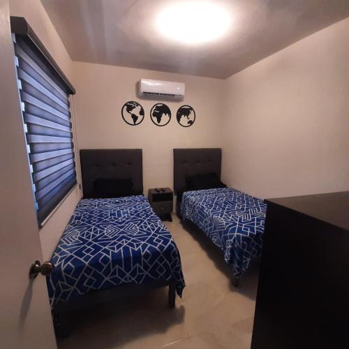 2 camas en un dormitorio con edredón azul en Hospedaje en Salamanca Residencial en Hermosillo