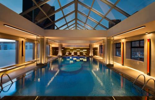 北京的住宿－北京希爾頓酒店，一座带玻璃天花板的大型游泳池