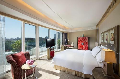 a bedroom with a white bed and a large window at Hilton Beijing - Close to Capital Airport Express Subway & Liangma River located in the Embassy area in Beijing