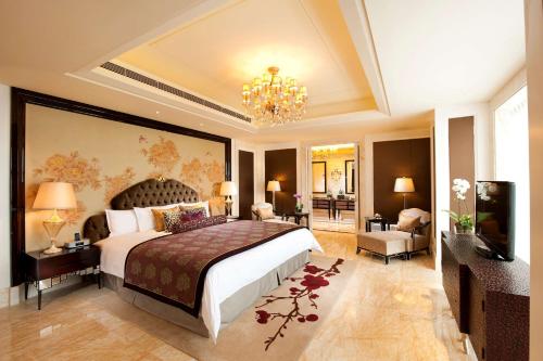 a bedroom with a large bed and a chandelier at Hilton Guangzhou Baiyun - Canton Fair Free Shuttle Bus in Guangzhou