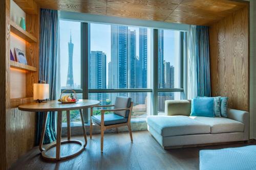 a living room with a table and a large window at Conrad Guangzhou - Free shuttle between hotel and Exhibition Center during Canton Fair & Exhibitor registration Counter in Guangzhou