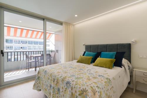 a bedroom with a bed and a balcony with a table at RENOVADO APARTAMENTO 1º LINEA DE MAR in San Agustin