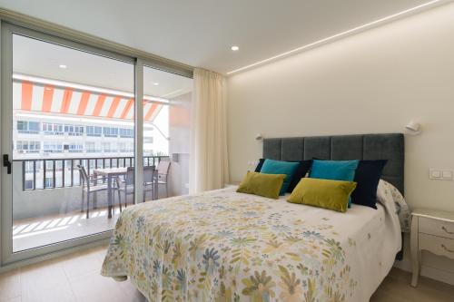 a bedroom with a bed and a balcony with a table at RENOVADO APARTAMENTO 1º LINEA DE MAR in San Agustin