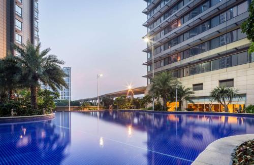 een groot zwembad voor een gebouw bij Hilton Foshan in Foshan