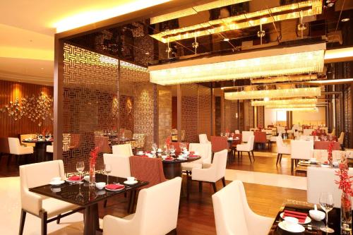 a dining room with tables and white chairs at DoubleTree by Hilton Hangzhou East in Hangzhou