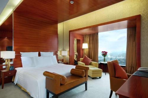 a bedroom with a large bed and a large window at Hilton Hefei in Hefei