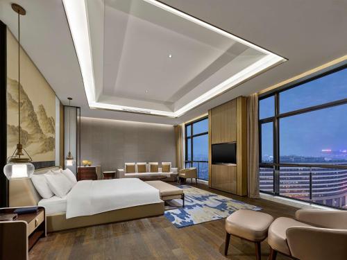 衢州にあるDoubletree By Hilton Quzhouのベッドと大きな窓が備わるホテルルームです。