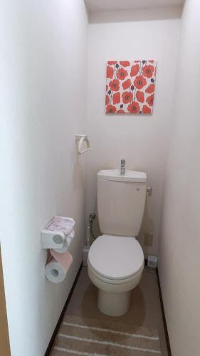 uma casa de banho com WC e uma pintura na parede em Takamatsu-house201 em Shimminatomachi