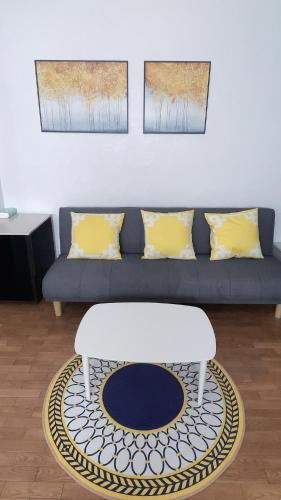 uma sala de estar com um sofá azul com almofadas amarelas em Takamatsu-house201 em Shimminatomachi