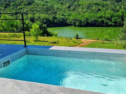 a large swimming pool with a view of a lake at Glamping A frame lake in Barajevo