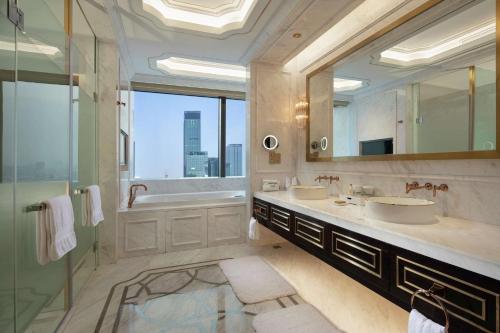 a bathroom with two sinks and a large mirror at Hilton Shenyang in Shenyang