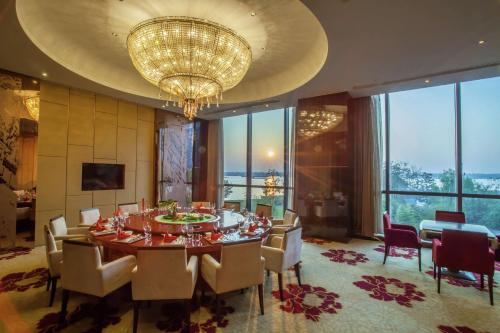 a dining room with a table and chairs and a chandelier at DoubleTree by Hilton Wuhu in Wuhu