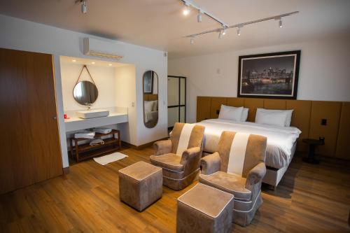 une chambre d'hôtel avec un lit et deux chaises dans l'établissement ibis Catanduva, à Catanduva