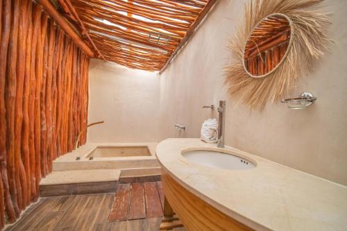 a bathroom with a sink and a toilet in it at SelvaLuz Tulum Resort & Spa in Tulum