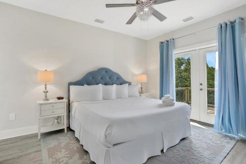 a white bedroom with a large bed and a window at Fruitcakes in St. George Island