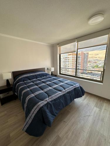 a bedroom with a large bed and a large window at Departamento 1D1B Condominio Altos de Huayquique in Iquique