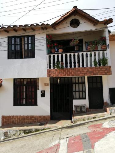 a white house with black doors and a balcony at Hostal en la 17 in Socorro