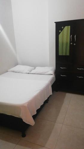 a bedroom with two beds and a dresser with a television at Hostal en la 17 in Socorro