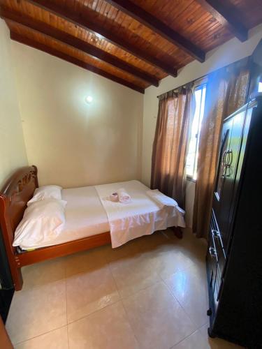 ein kleines Schlafzimmer mit einem Bett in einem Zimmer in der Unterkunft Hostal en la 17 in Socorro