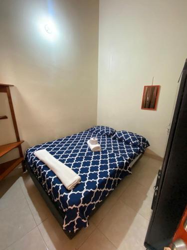 Una cama en una habitación con dos toallas. en Hostal en la 17 en Socorro