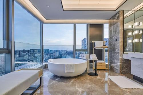 a bath tub in a bathroom with a view at Doubletree By Hilton Shenzhen Airport in Bao'an