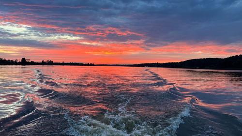 a view of a body of water at sunset at Urocza chatka w lesie nad wodą in Skubianka