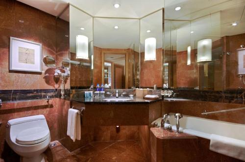 y baño con bañera, aseo y lavamanos. en Hilton Chongqing, en Chongqing