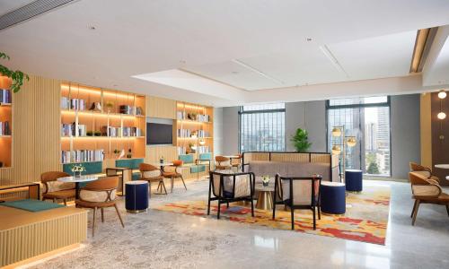 a library with tables and chairs and bookshelves at Hilton Garden Inn Shenzhen Nanshan Avenue in Shenzhen