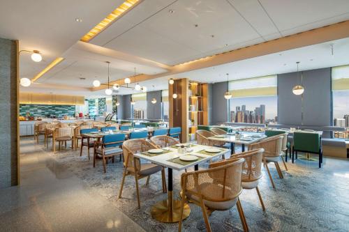 uma sala de jantar com mesas e cadeiras num restaurante em Hilton Garden Inn Shenzhen Nanshan Avenue em Shenzhen