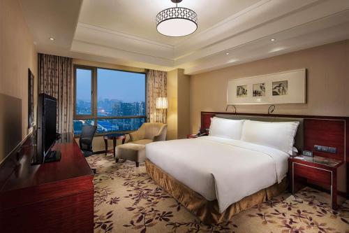 een hotelkamer met een groot bed en een televisie bij DoubleTree By Hilton Wuxi in Wuxi