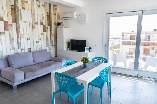 Una sala de estar con un sofá, una mesa y sillas. en Edilia Vacanze, en Marina di Ragusa