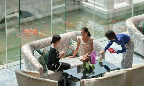a woman and two children sitting around a table in a room with water at DoubleTree By Hilton Wuxi in Wuxi