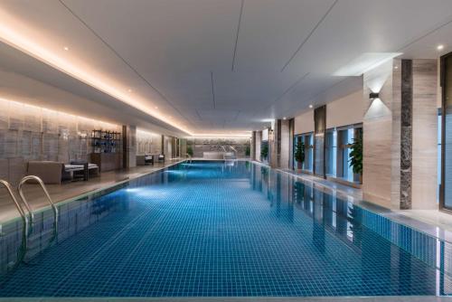 una gran piscina en el vestíbulo del hotel con una gran piscina en DoubleTree by Hilton Hotel Shiyan en Shiyan