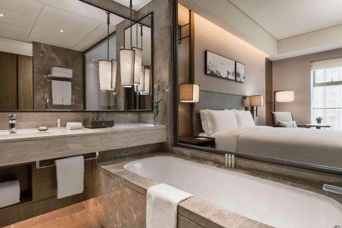 baño con bañera y cama en DoubleTree by Hilton Hotel Shiyan, en Shiyan