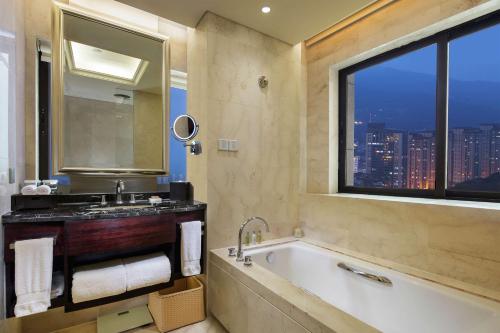 La salle de bains est pourvue d'une baignoire, d'un lavabo et d'une fenêtre. dans l'établissement DoubleTree by Hilton Hotel Putian, à Putian