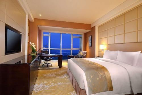 a hotel room with a bed and a desk and a television at DoubleTree by Hilton Hotel Putian in Putian