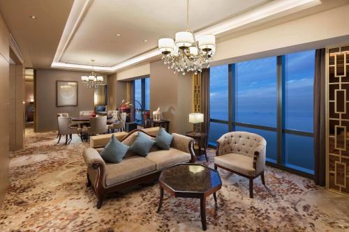 a living room with a couch and chairs and a table at Hilton Yantai in Yantai