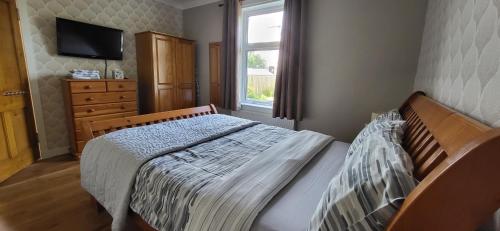 a bedroom with a bed and a dresser and a window at Musselburgh / Edinburgh near QM Uni (30) in Fisherrow