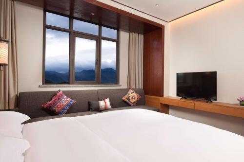 a hotel room with a large bed and a television at Hilton Garden Inn Shangri-La in Shangri-La