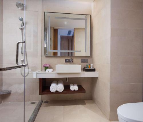 a bathroom with a sink and a mirror at Hilton Garden Inn Shangri-La in Shangri-La