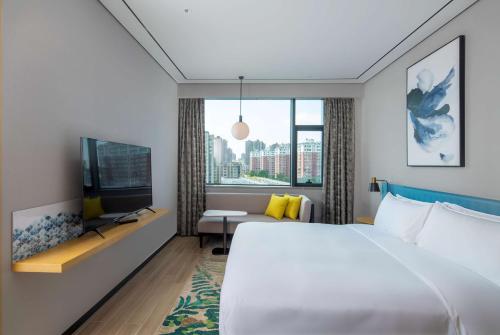 a hotel room with a bed and a tv at Hilton Garden Inn Changchun Economic Development Zone in Changchun